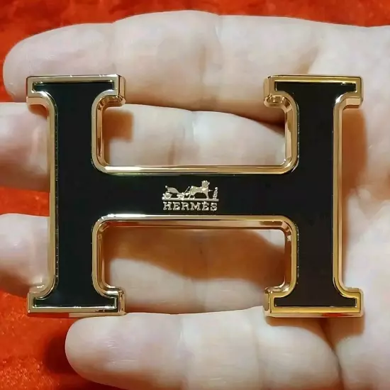 HERMES. Belt buckle with "HERMES" inscription. Gold-black tone. 